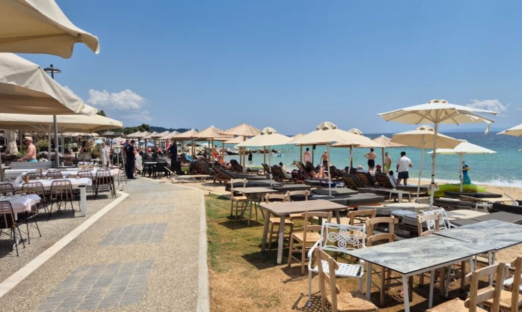 Plaja din Grecia unde o sticlă cu apă minerală costă 35 de lei. Mulți români își petrec acolo vacanța de vară în 2026